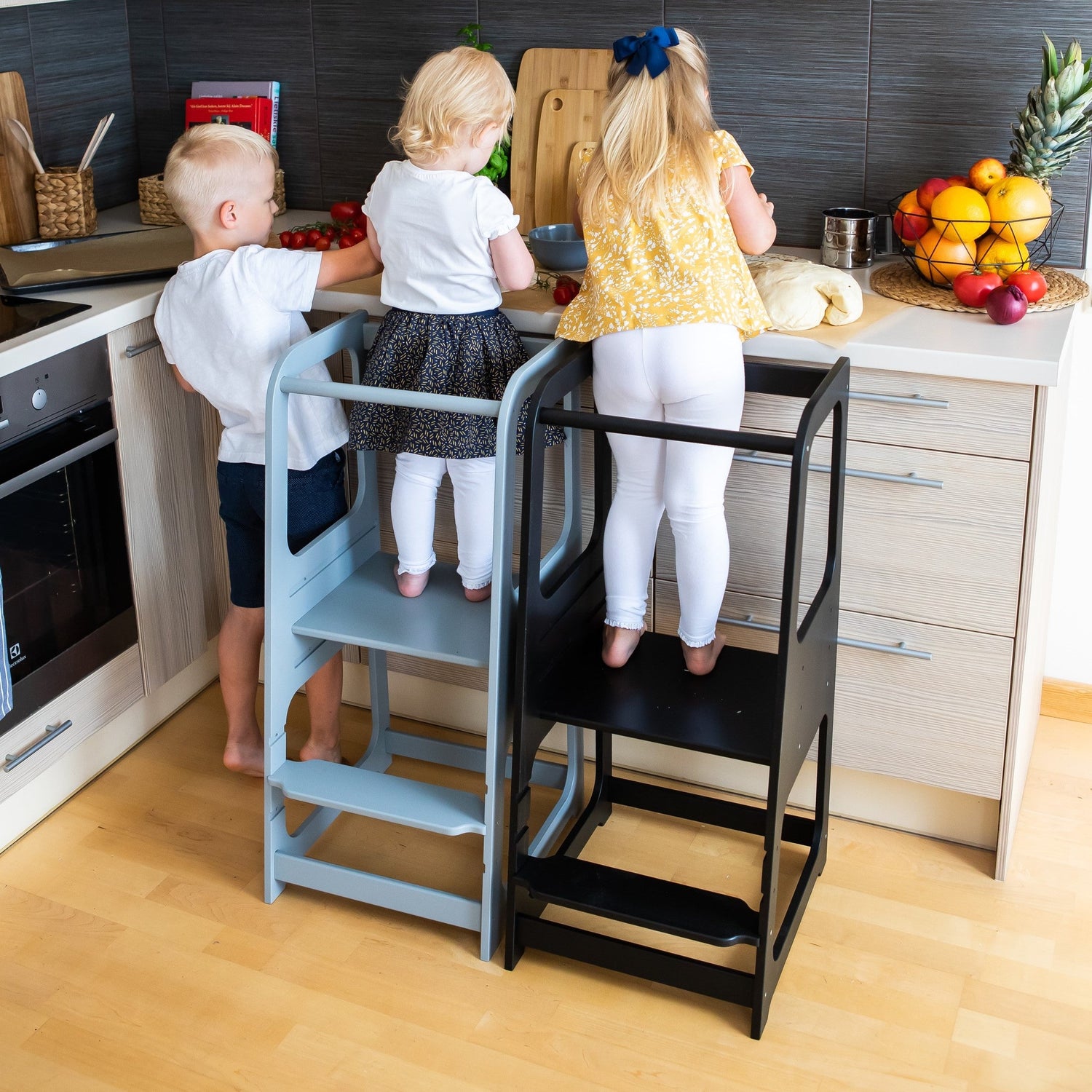children cooking in cozy kitchen using montessori towers